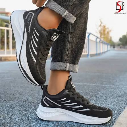 Black and white running sneakers worn on a city street